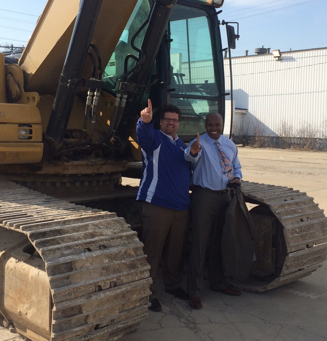 Gary Woodward and a colleague celebrating a heavy equipment sale